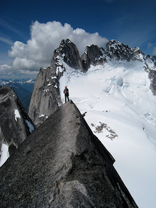 Climber enjoying the view on the W. Ridge of Pigeon Spire in the Bugaboos.
